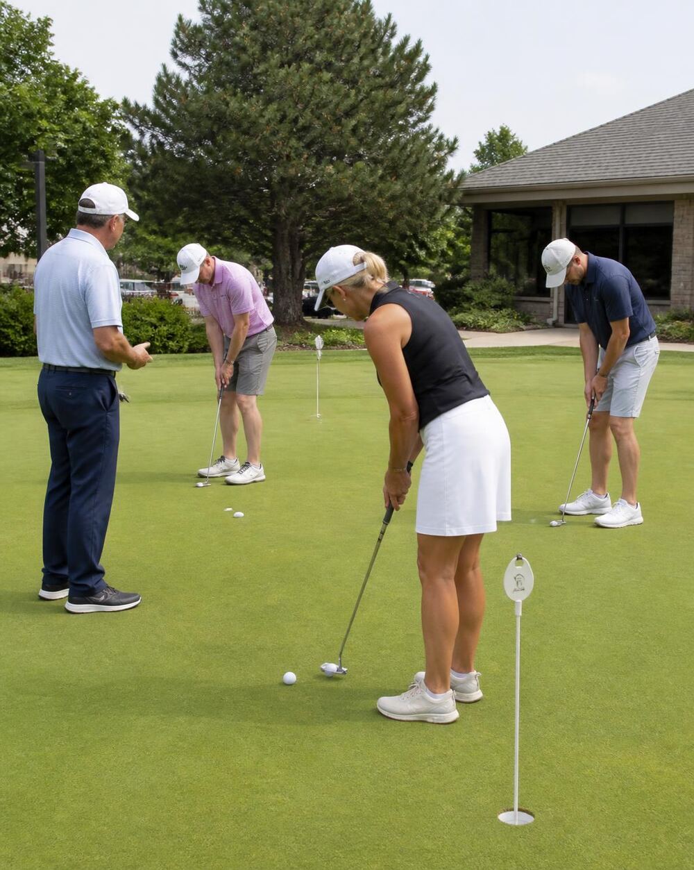 Small group clinic working on putting while the coach observes